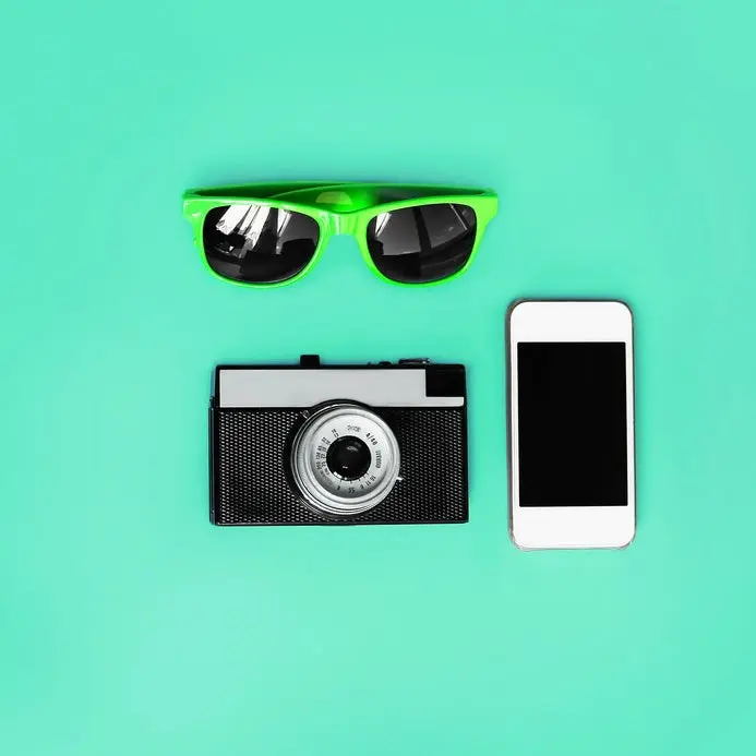 Fashion accessory. Sunglasses, vintage camera and smartphone on