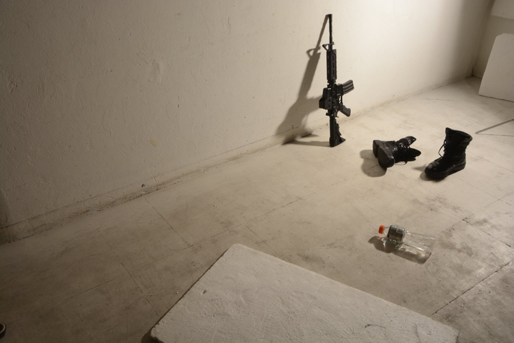 fotografia de un arma recostada sobre una pared