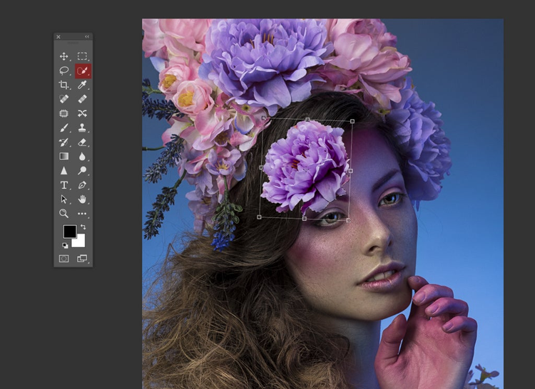 fotografia del rostro de una mujer sobre su cabeza un ramo de flores de color rosa y morado