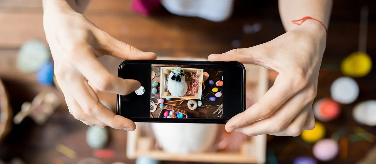 joven con su telefono en las manos tomando una fotografia de una caja con un conejo dentro creando contenido para redes sociales 