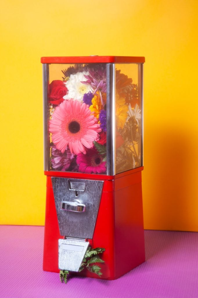 Maquinita de chicles con flores de colores en su interior