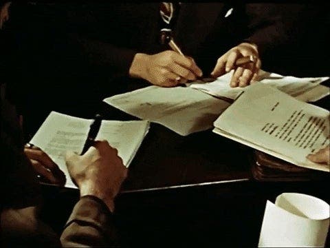 manos de personas ejecutivas firmando documentos