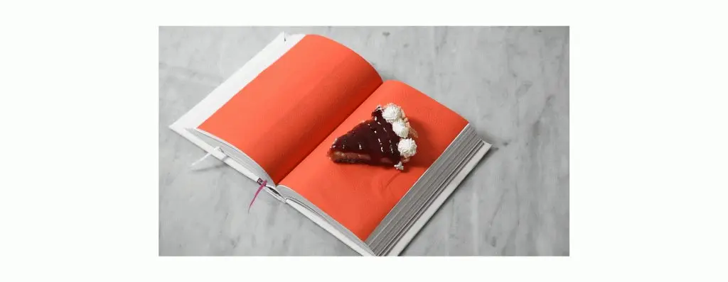 libro naranjan con ua porcion de torta