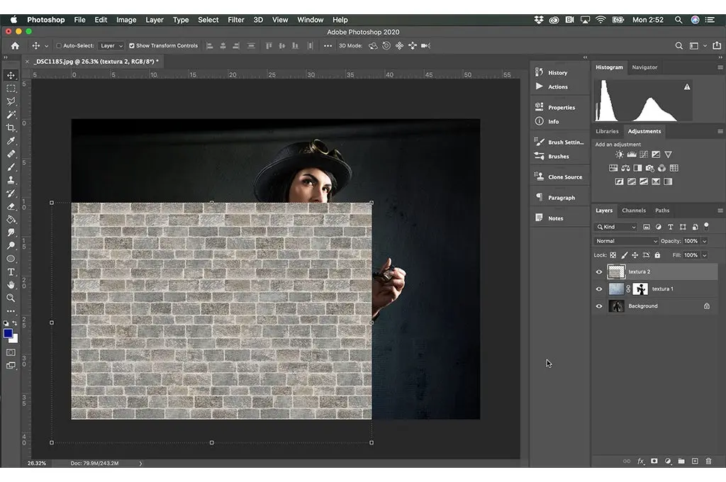 interfaz de Photoshop en ejecucion la imagen de una mujer vestida de negro sobre ella una textura de una pared de ladrillo