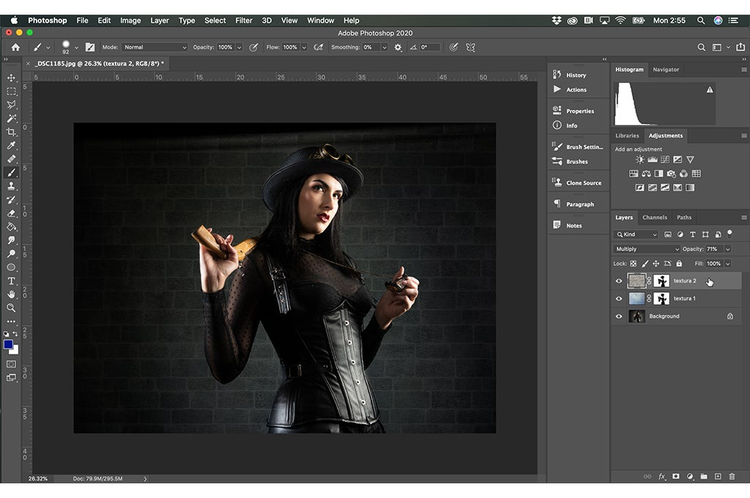 interfaz de Photoshop en ejecucion la imagen de una mujer vestida de negro sosteniendo un arma en su hombro y un collar en su otra mano detras un fondo de ladrillo modo fusion final