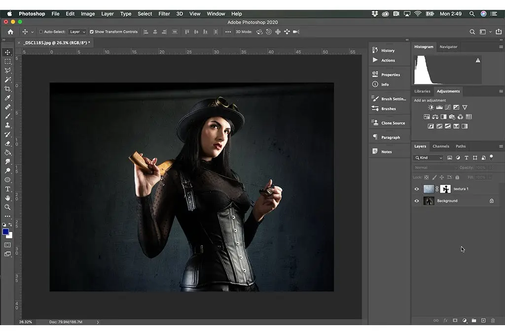 interfaz de Photoshop en ejecucion la imagen de una mujer vestida de negro sosteniendo un arma y un collar en sus manos