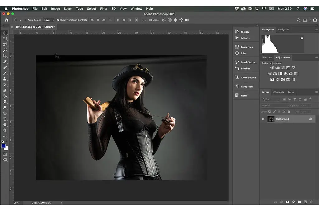 interfaz de Photoshop en ejecucion la imagen de una mujer vestida de negro sosteniendo un arma sobre su hombro y en su otra mano sosteniendo un collar que cuelga de su cuello