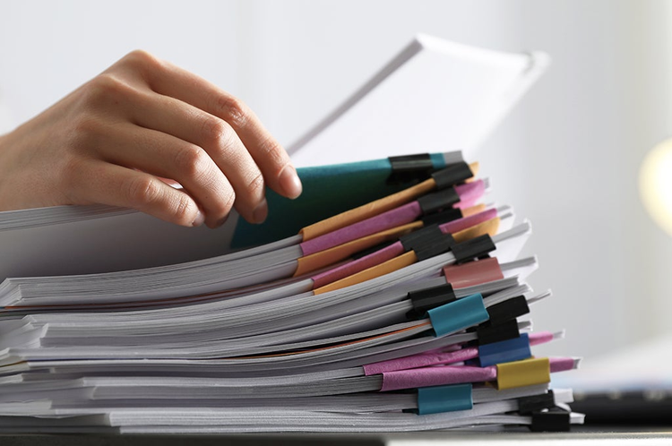 mano de una persona organizando un listado de documentos