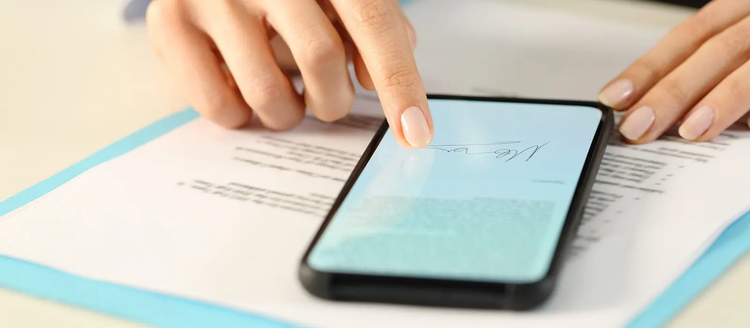 Manos de una joven firmando un documento en su telefono celular, firma con Adobe fill & sign