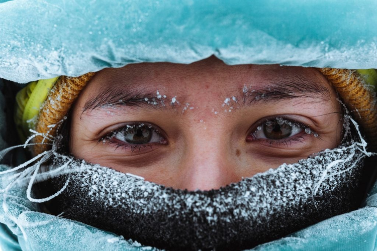rostro de una mujer cubriendose del frio en temperaturas bajo cero 