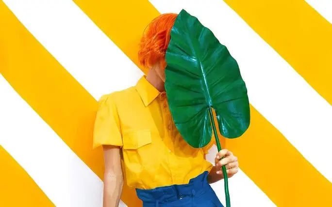 mujer sosteniendo una rama y con ella ocultando su rostro detras un fondo con lineas blancas y amarillas, Photoshop para iPad