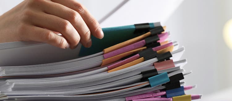 mano de una persona humana organizando un listado de documentos