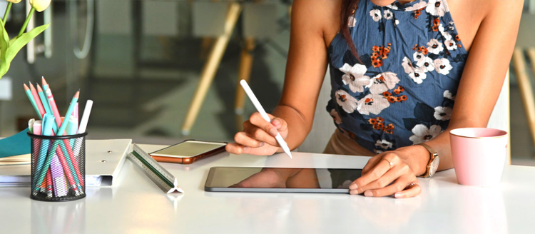 Mujer utilizando los pogramas de adobe y su applepencil en su tablet 