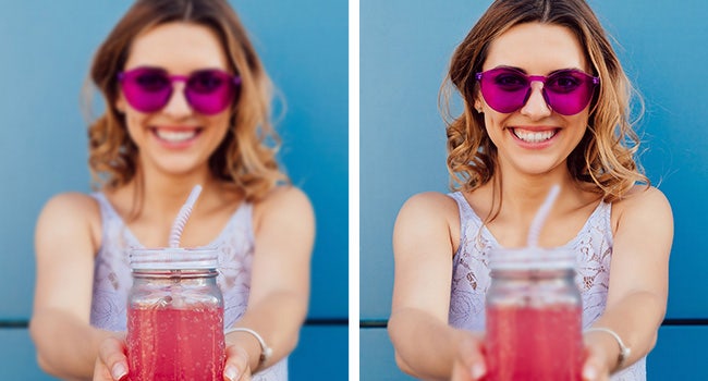 A person wearing sunglasses and holding a glass of juice Description automatically generated