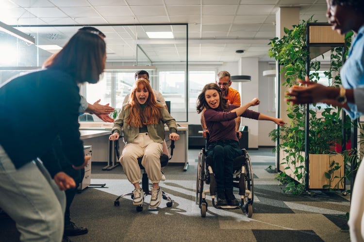 Woman who uses a wheelchair is winning the office chair race with her colleagues.