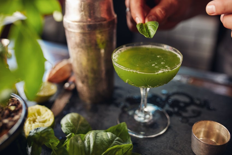 Barman preparing basil smash cocktail