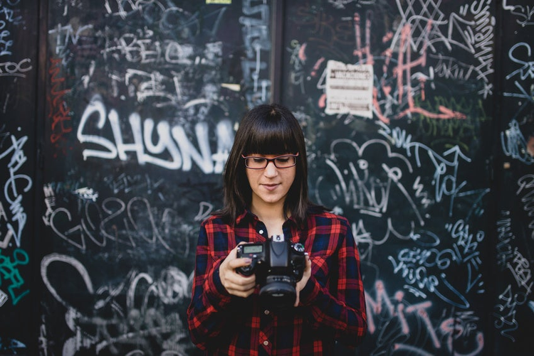 Young woman using a camera on the street