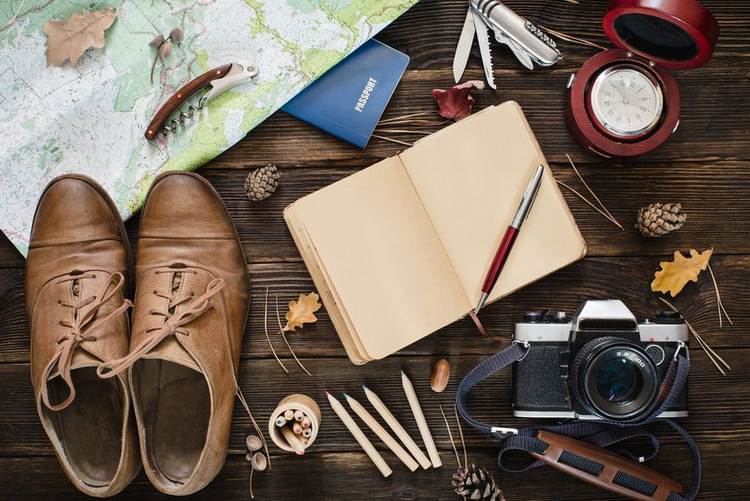 Top view of modern collection for travel on wooden background. Autumn mood concept