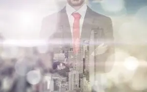 Double exposure with business man and city skyline