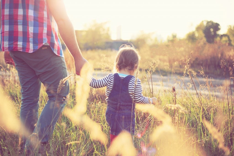 Toddler girl playing with daddy in the garden