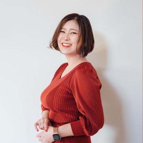オレンジ色のシャツを着ている女性 低い精度で自動的に生成された説明