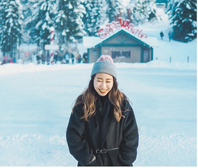 雪の上にいる帽子をかぶった女性 低い精度で自動的に生成された説明