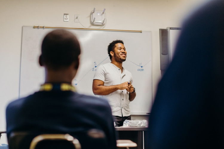 Teacher standing in front of the whiteboard. 