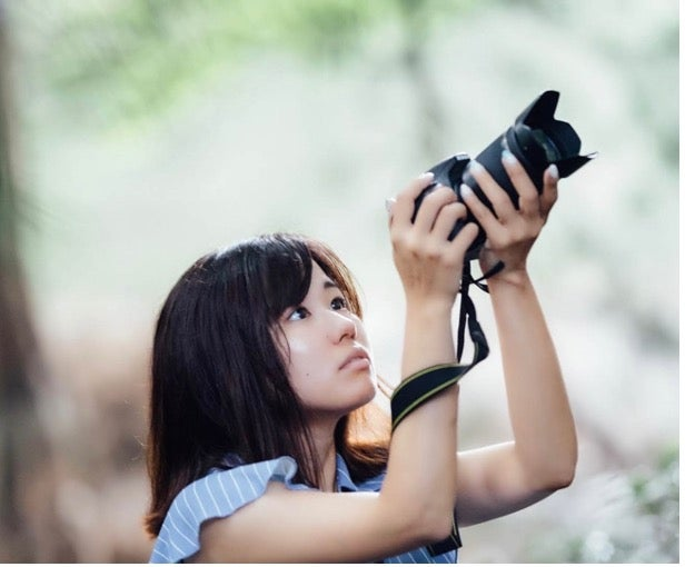 携帯電話で写真を撮っている女性 中程度の精度で自動的に生成された説明