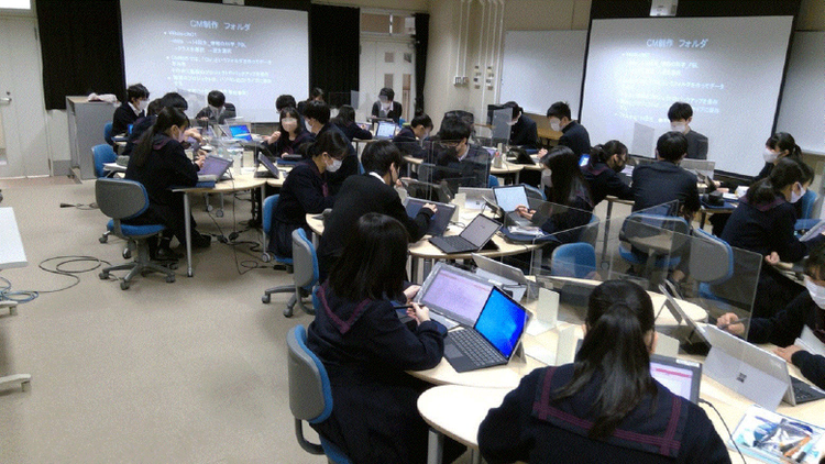 A group of people sitting in a room with laptops Description automatically generated with low confidence