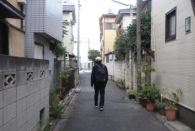 家の前の歩道を歩いている男性 中程度の精度で自動的に生成された説明