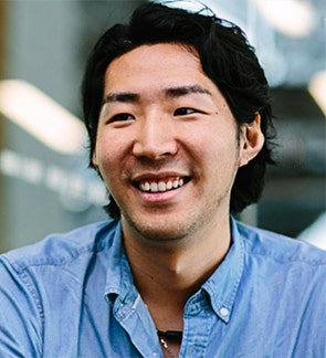 青いシャツを着ている男性 自動的に生成された説明