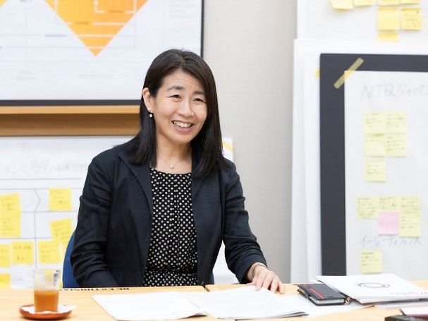 デスクに座っている女性 中程度の精度で自動的に生成された説明