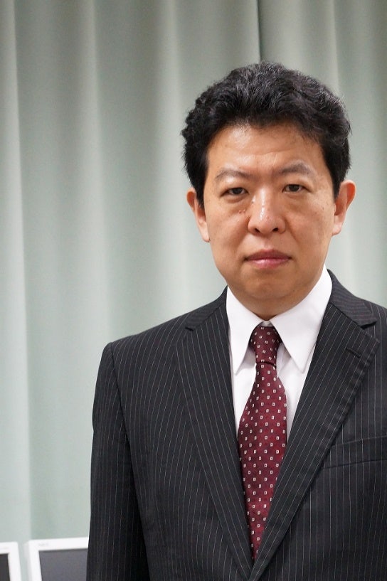 A person in a suit and tie Description automatically generated with medium confidence