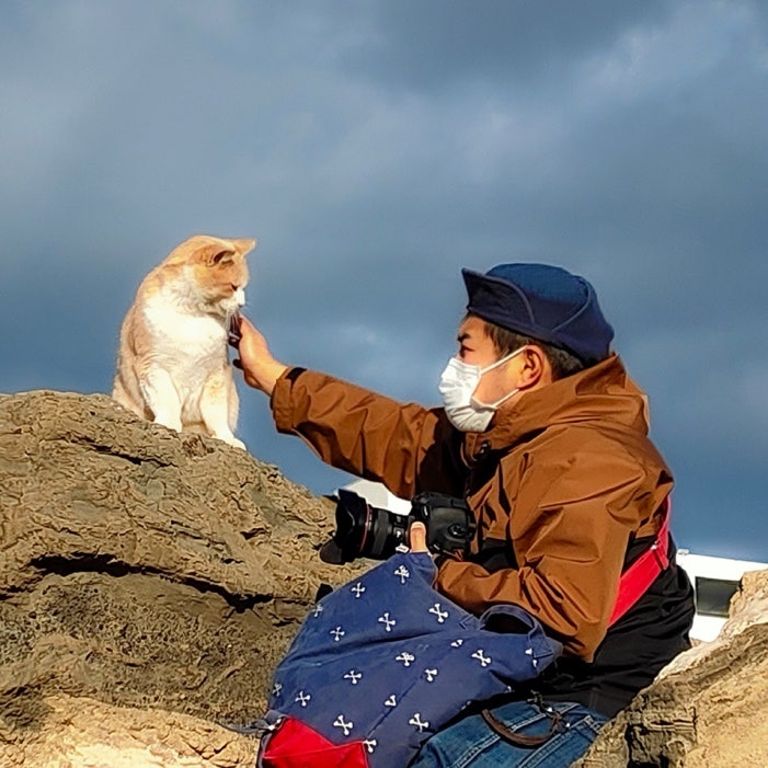 岩の上に横たわっている人と犬 低い精度で自動的に生成された説明
