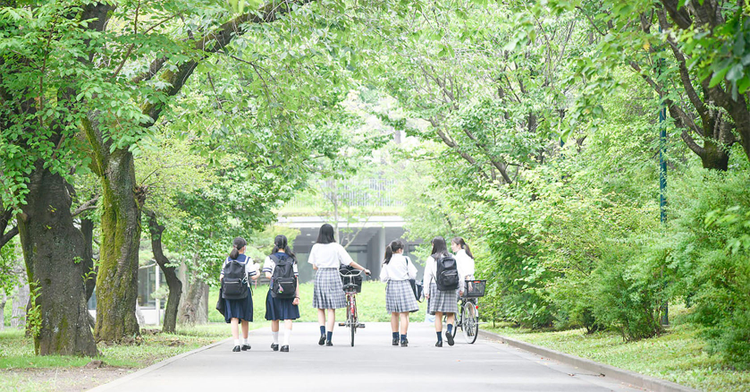 A group of people walking down a road with trees on either side
Description automatically generated with medium confidence