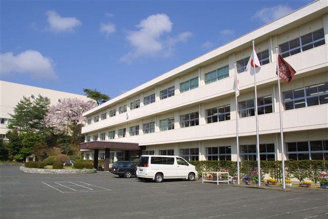 建物の前にある駐車場 中程度の精度で自動的に生成された説明
