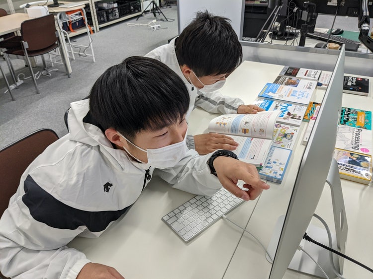 本を読んでいる子供 低い精度で自動的に生成された説明