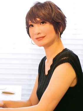 白い壁の前にいる女性 自動的に生成された説明