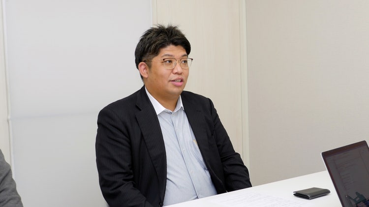 スーツを着た男性 自動的に生成された説明