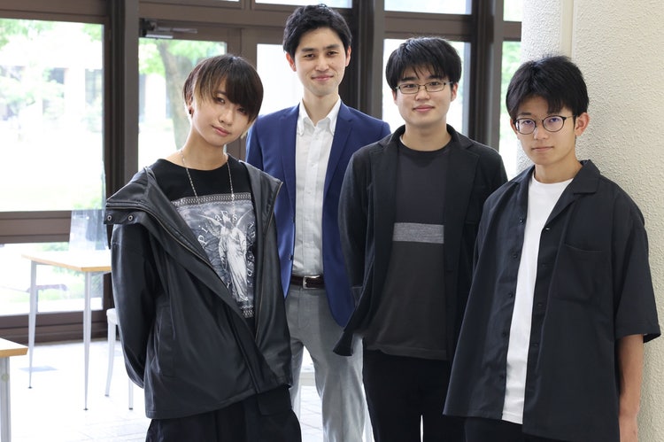 窓の前に立っている男性たち 中程度の精度で自動的に生成された説明