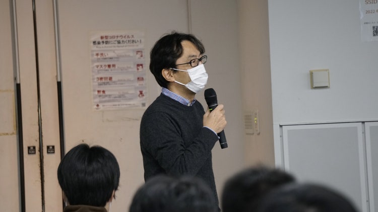 鏡越しに携帯で写真を撮る男性 低い精度で自動的に生成された説明