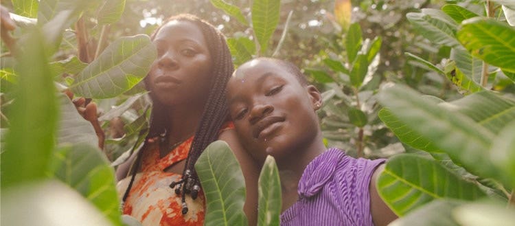 Portrait of a black african mother and daughter farmer standing within nature under the sunlight.