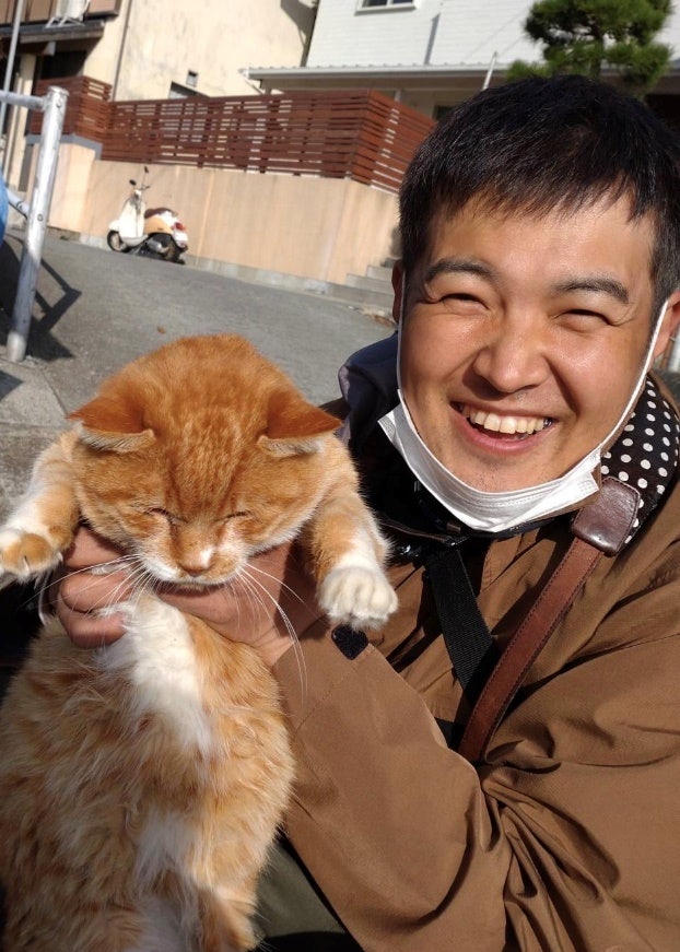 A person holding a cat Description automatically generated