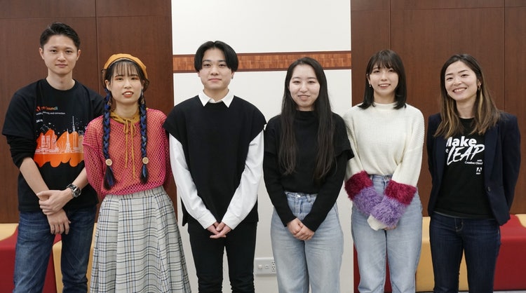 ポーズをとる男女のグループ 自動的に生成された説明