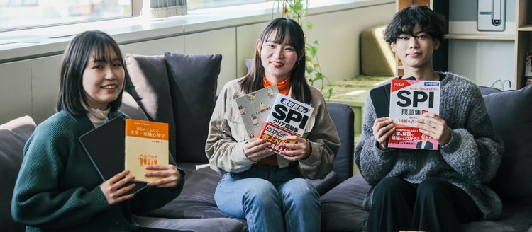A group of women sitting on a couch holding books Description automatically generated with medium confidence