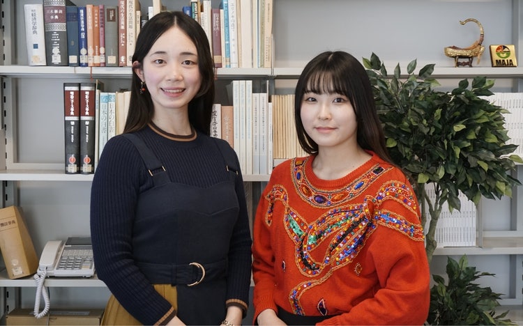 棚に並んで立っている女性 中程度の精度で自動的に生成された説明