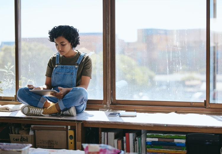 ベンチに座ってタブレットを操作する少女