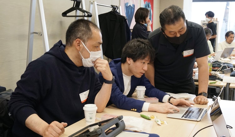ノートパソコンで作業をしている人たち 中程度の精度で自動的に生成された説明