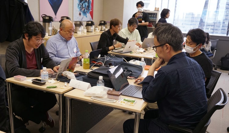 ノートパソコンで作業をしている人たち 自動的に生成された説明