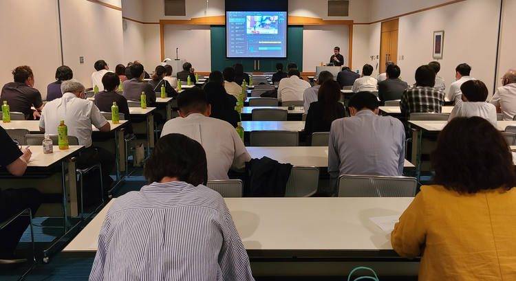 机の上に座っている人たち 低い精度で自動的に生成された説明